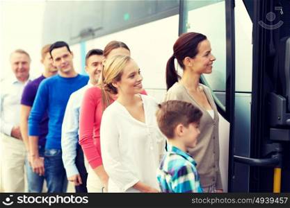 transport, tourism, road trip and people concept - group of happy passengers boarding travel bus. group of happy passengers boarding travel bus