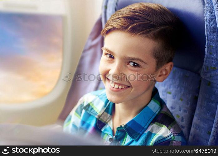 transport, tourism, road trip and people concept - happy boy travelling by plane over porthole background. happy boy travelling by plane. happy boy travelling by plane