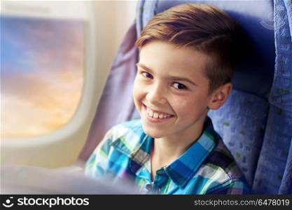 transport, tourism, road trip and people concept - happy boy travelling by plane over porthole background. happy boy travelling by plane. happy boy travelling by plane