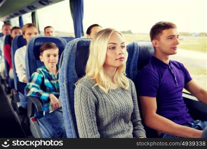 transport, tourism, road trip and people concept - happy couple with group of passengers or tourists in travel bus. happy couple or passengers in travel bus