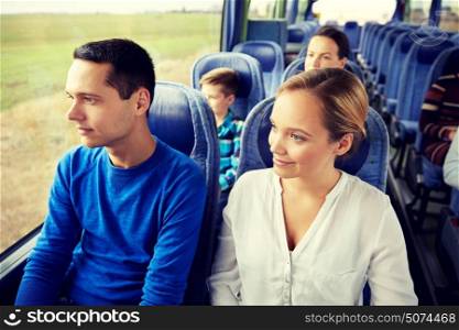 transport, tourism, road trip and people concept - happy couple with group of happy passengers or tourists in travel bus. happy couple or passengers in travel bus