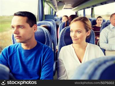 transport, tourism, road trip and people concept - happy couple with group of happy passengers or tourists in travel bus. happy couple or passengers in travel bus