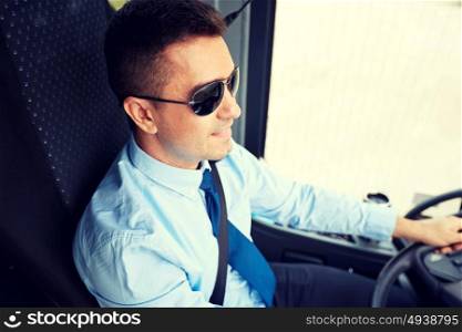 transport, tourism, road trip and people concept - happy driver driving intercity bus. happy driver driving intercity bus