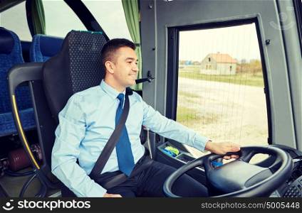 transport, tourism, road trip and people concept - happy driver talking to microphone and driving bus. happy driver talking to microphone and driving bus