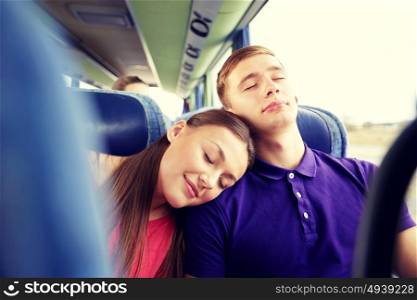 transport, tourism, road trip and people concept - happy teenage couple or tourists sleeping on shoulder in travel bus. happy couple or passengers sleeping in travel bus