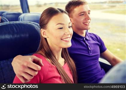 transport, tourism, road trip and people concept - happy teenage couple or tourists hugging in travel bus. happy teenage couple or passengers in travel bus