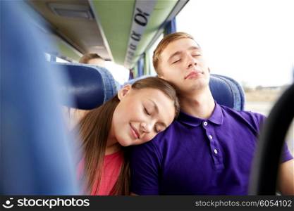 transport, tourism, road trip and people concept - happy teenage couple or tourists sleeping on shoulder in travel bus