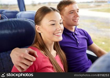 transport, tourism, road trip and people concept - happy teenage couple or tourists hugging in travel bus