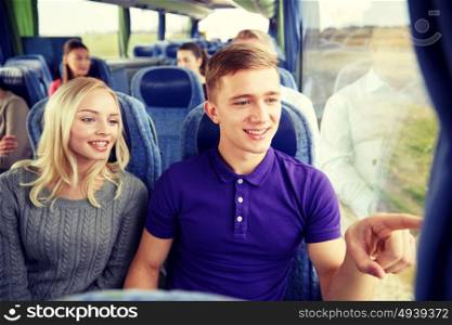 transport, tourism, road trip and people concept - happy teenage couple with group of passengers or tourists in travel bus. happy teenage couple or passengers in travel bus