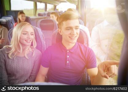 transport, tourism, road trip and people concept - happy teenage couple with group of passengers or tourists in travel bus