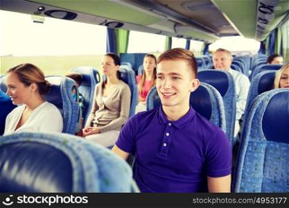 transport, tourism, road trip and people concept - happy young man sitting in travel bus or train. happy young man sitting in travel bus or train