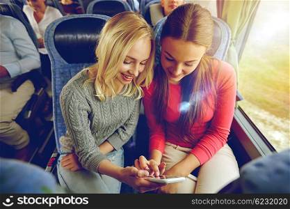transport, tourism, road trip and people concept - happy young women or friends in travel bus texting or reading message on smartphone