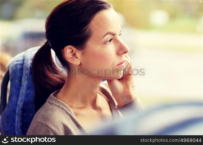 transport, tourism, road trip and people concept - young woman in travel bus or train calling on smartphone. woman in travel bus calling on smartphone