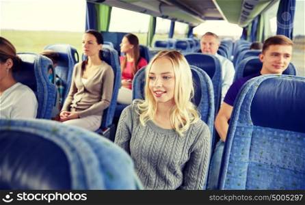 transport, tourism, road trip and people concept - young woman with group of passengers or tourists in travel bus. group of passengers or tourists in travel bus