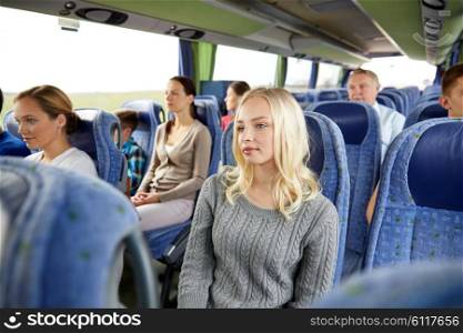 transport, tourism, road trip and people concept - young woman with group of passengers or tourists in travel bus
