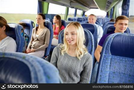 transport, tourism, road trip and people concept - young woman with group of passengers or tourists in travel bus