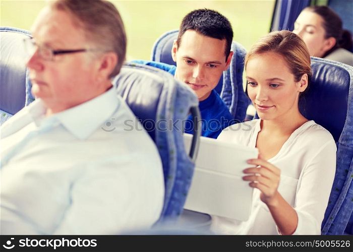 transport, tourism, road trip, technology and people concept - happy couple with tablet pc in travel bus. happy couple with tablet pc in travel bus