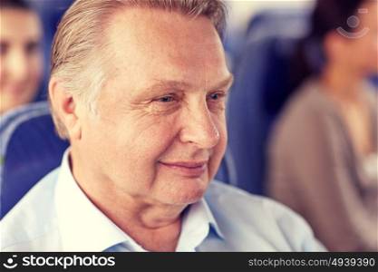 transport, tourism, trip and people concept - happy senior man sitting in travel bus or airplane. happy senior man sitting in travel bus or airplane