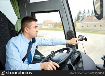 transport, transportation, navigation and people concept - bus driver entering address to gps navigator