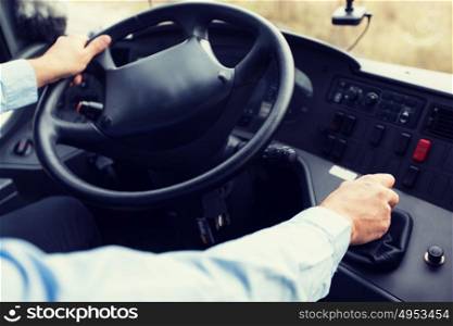 transport, transportation, tourism, road trip and people concept - close up of bus driver steering wheel and driving passenger bus. close up of driver driving passenger bus