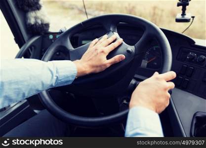 transport, transportation, tourism, road trip and people concept - close up of bus driver holding wheel driving passenger bus. close up of driver driving passenger bus