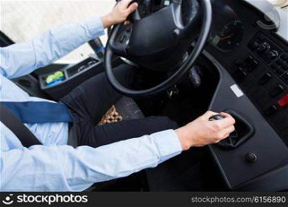 transport, transportation, tourism, road trip and people concept - close up of bus driver steering wheel and driving passenger bus