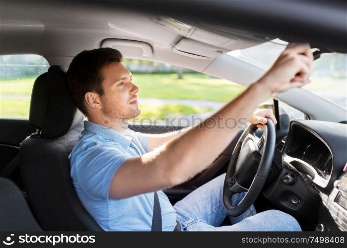 transport, vehicle and driving concept - man or car driver adjusting mirror in summer. man or car driver adjusting mirror