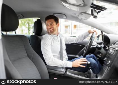 transport, vehicle and driving concept - smiling man or car driver looking back. smiling man or driver driving car