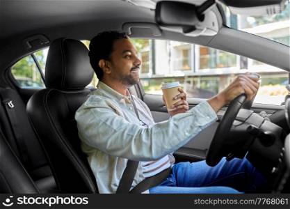 transport, vehicle and people concept - happy smiling indian man or driver with takeaway coffee cup driving car. happy indian man or driver with coffee driving car