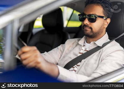 transport, vehicle and people concept - happy smiling indian man or driver in sunglasses driving car. smiling indian man in sunglasses driving car