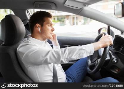 transport, vehicle and people concept - man or driver with wireless earphones or hands free device driving car. man or driver with wireless earphones driving car