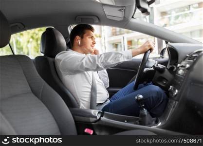 transport, vehicle and people concept - man or driver with wireless earphones or hands free device driving car. man or driver with wireless earphones driving car