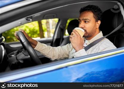 transport, vehicle and people concept - tired indian man or driver with takeaway coffee cup driving car. tired indian man or driver with coffee driving car