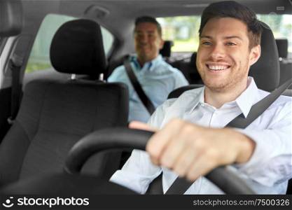 transport, vehicle and taxi concept - happy smiling male driver driving car with passenger. male taxi driver driving car with passenger