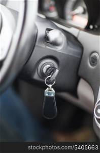 transportation and ownership concept - car key in ignition start lock