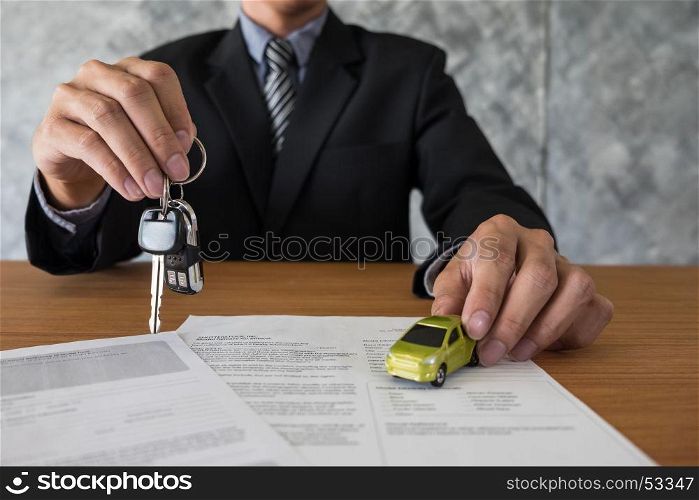 transportation and ownership concept - customer and salesman with car key