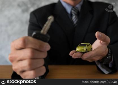 transportation and ownership concept - customer and salesman with car key
