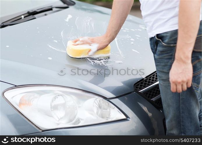 transportation and ownership concept - man washing a car