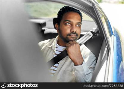 transportation and people concept - dreaming indian male passenger in taxi car. dreaming indian male passenger in taxi car