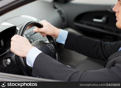 transportation and vehicle concept - businessman driving a car
