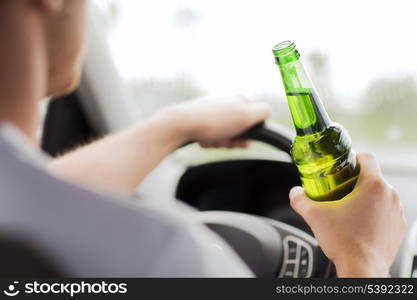 transportation and vehicle concept - man drinking alcohol while driving the car