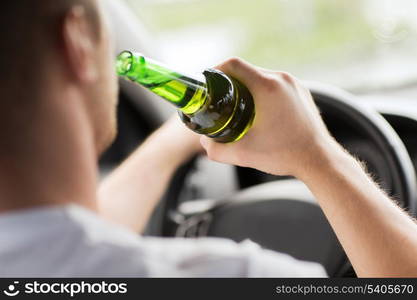 transportation and vehicle concept - man drinking alcohol while driving the car