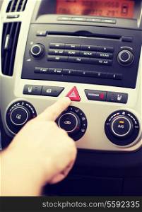 transportation and vehicle concept - man pressing red triangle car hazard warning button