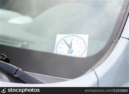 transportation and vehicle concept - parking clock on car dashboard under windscreen