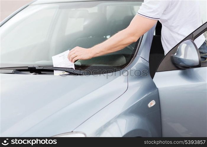 transportation and vehicle concept - parking ticket on car windscreen