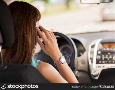 transportation and vehicle concept - woman using phone while driving the car