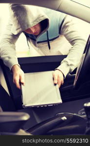 transportation, crime and ownership concept - thief stealing laptop from the car