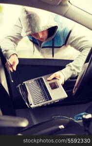 transportation, crime and ownership concept - thief stealing laptop from the car