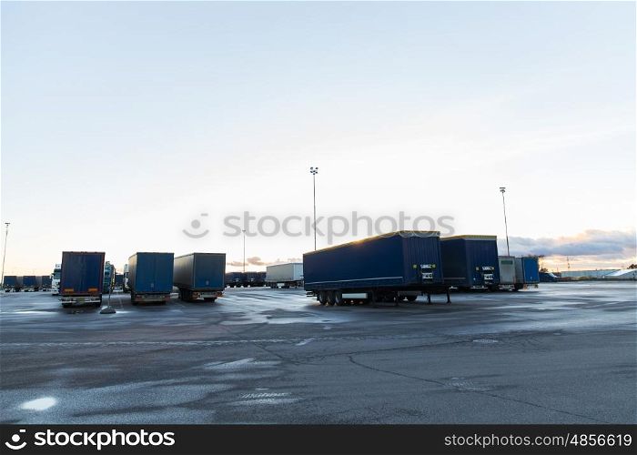 transportation, freight transport and vehicle concept - trucks and trailers on parking