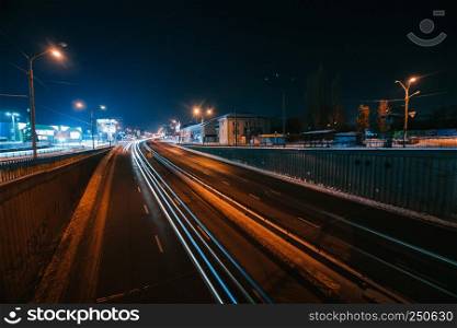 Transportation highway system with long exposure in dusk, shoted in Kyiv, Ukraine. Car trails on busy road.